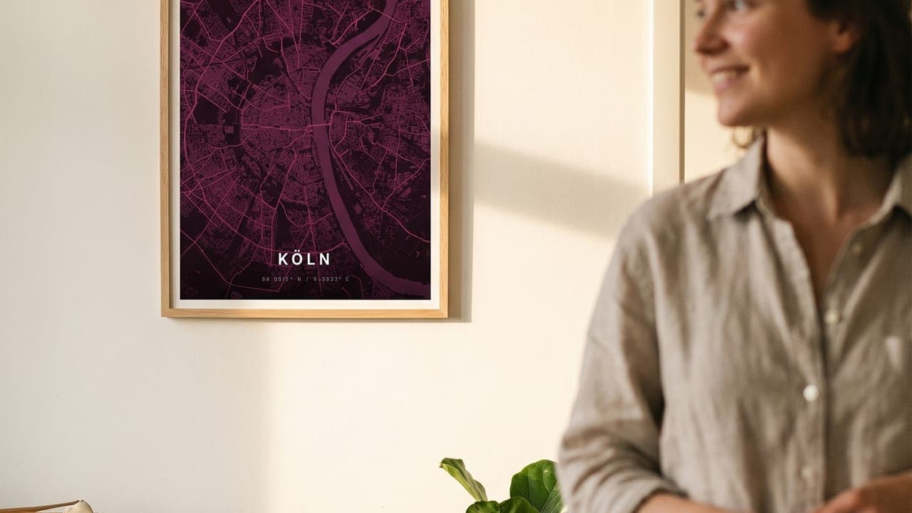 Smiling woman next to a Cologne map poster in a new flat with moving boxes