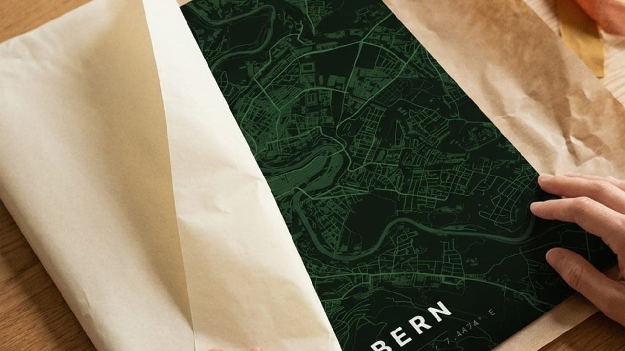 Hände packen ein grünes Bern-Kartenposter aus