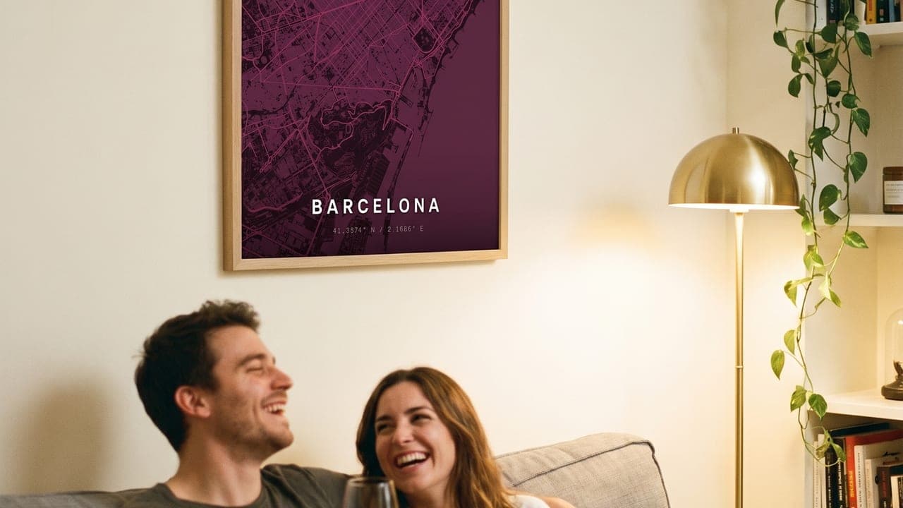 Couple with red wine on a sofa beneath a framed Barcelona map poster