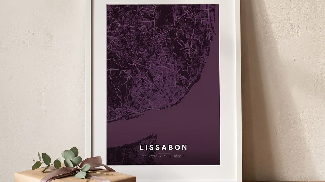 White-framed Lisbon map poster on a wooden table next to a gift with eucalyptus