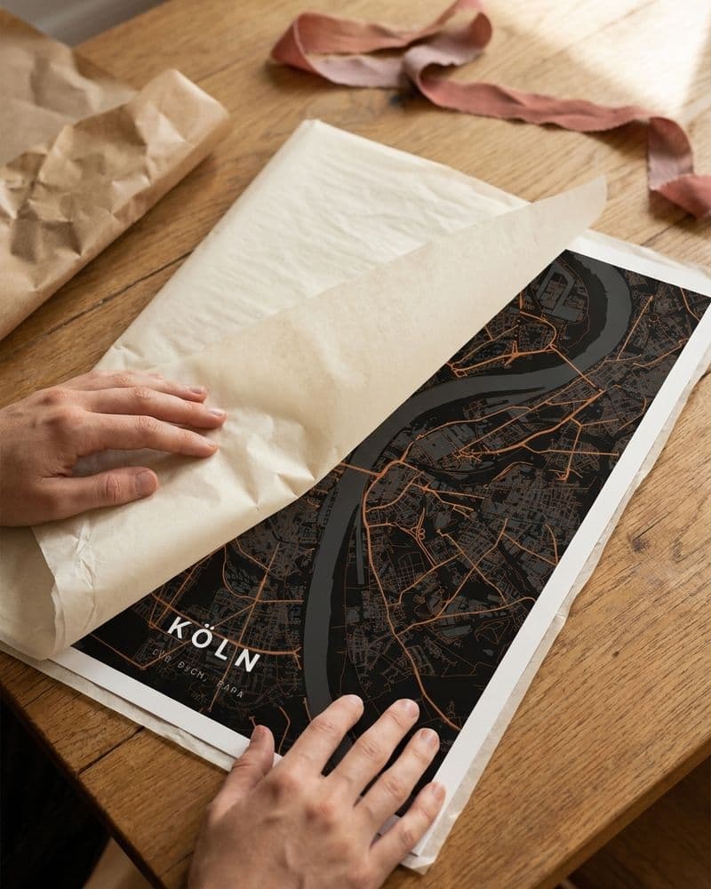 Hände packen ein Köln-Kartenposter aus