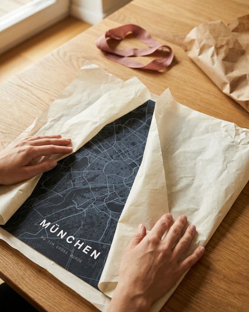 Hände packen ein München-Kartenposter aus