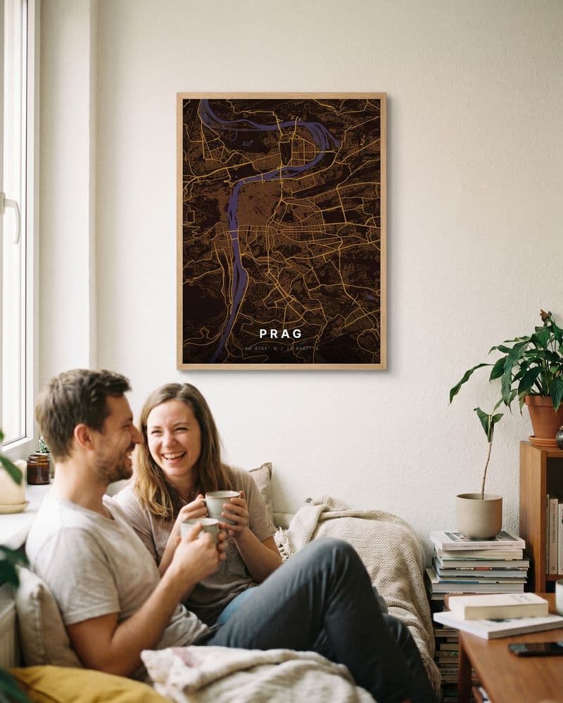 Paar mit Tassen auf dem Sofa unter einem Prag-Kartenposter