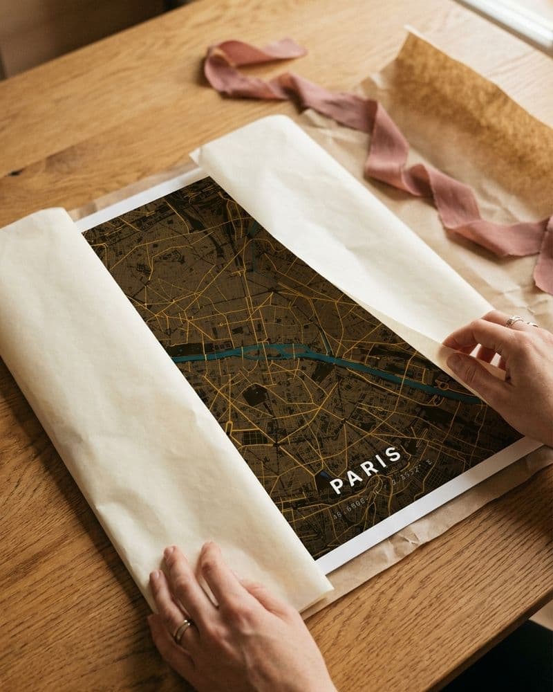 Hände packen ein Paris-Kartenposter aus