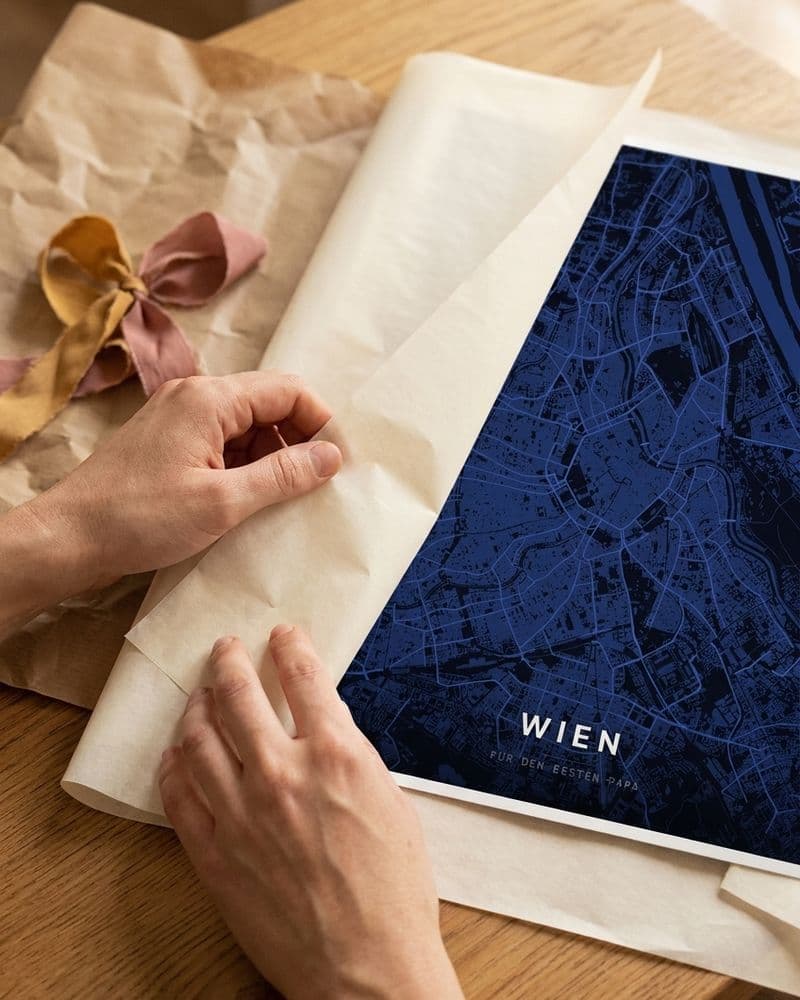 Hände packen ein Wien-Kartenposter aus Seidenpapier aus